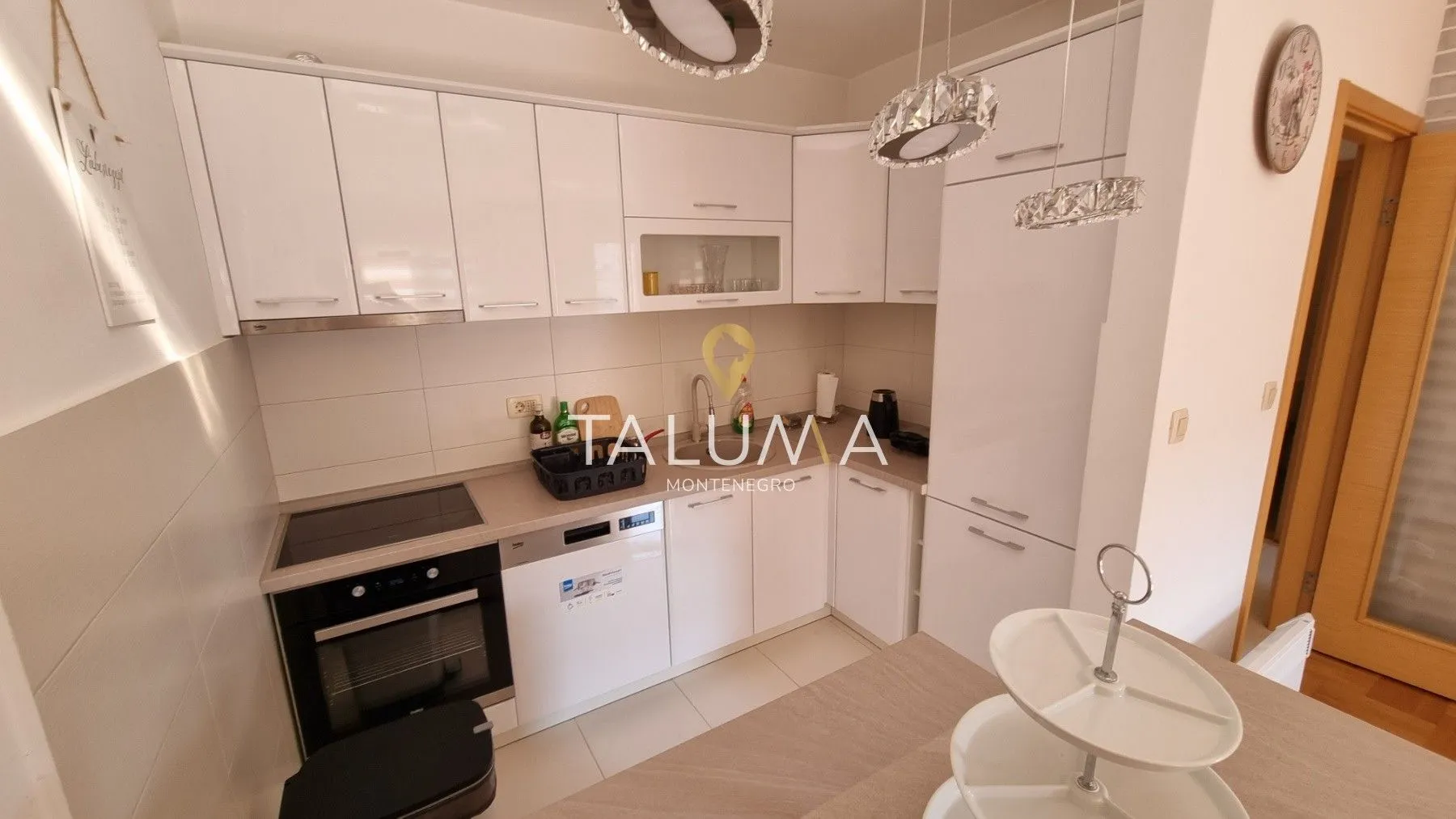 Kitchen equipped with white cabinetry and built-in appliances.