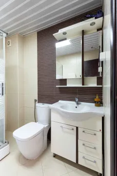 Manje kupatilo sa umivaonikom, WC šoljom i ogledalom sa ormarićem. - image 6