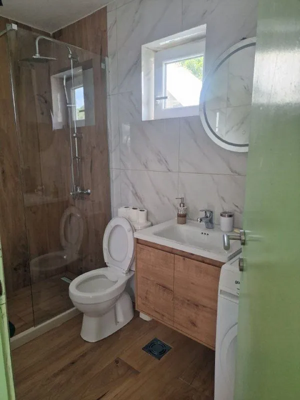Bathroom with a shower cabin, washbasin, and toilet.