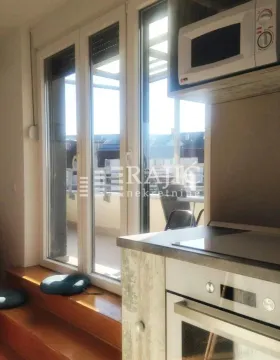 Small kitchen with built-in oven and microwave next to the balcony door. - image 4