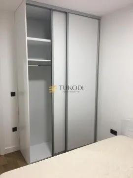 Spavaća soba sa velikim ugradnim garderoberom sa kliznim vratima i krevetom. - image 6