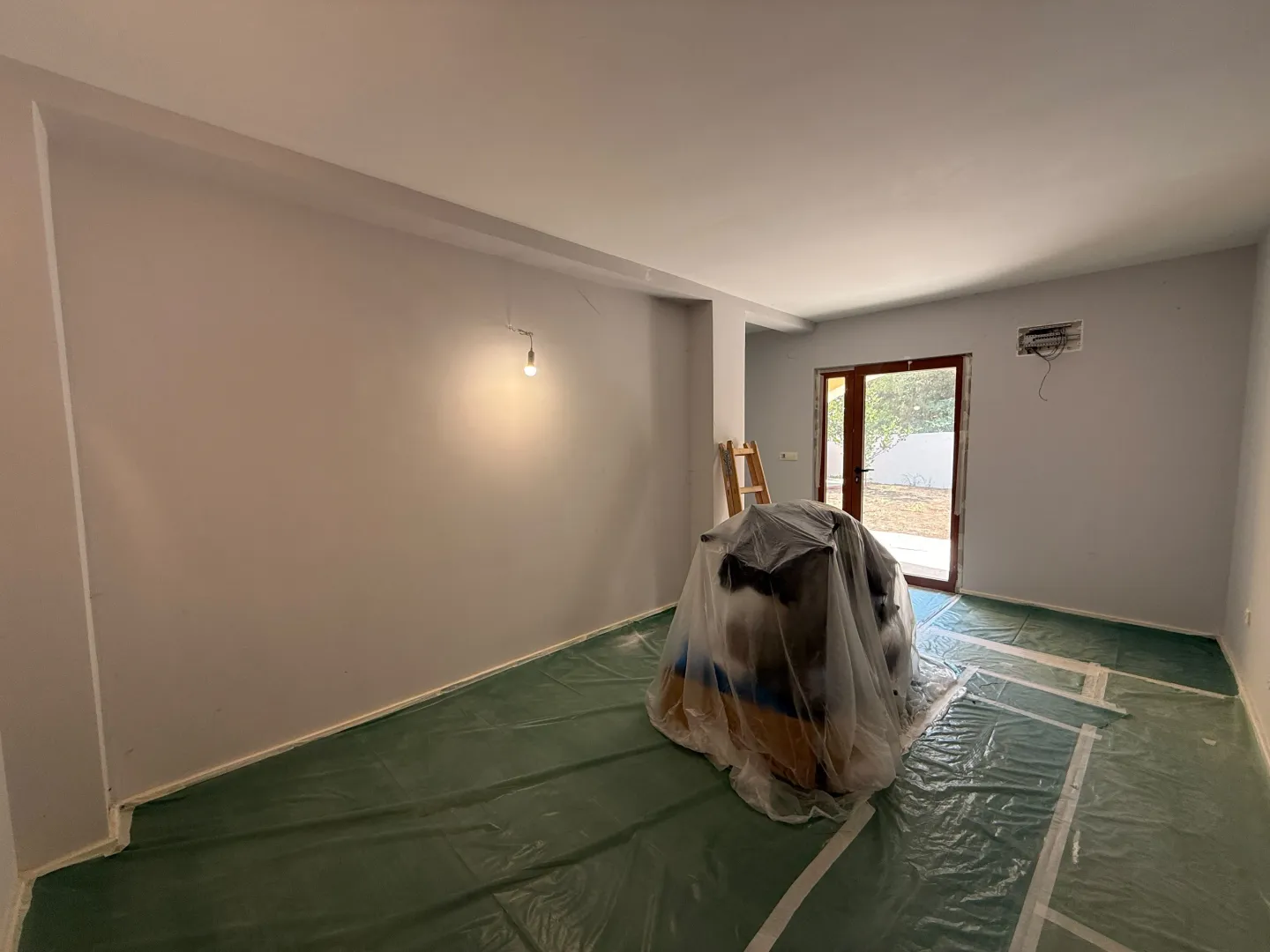 Prazna prostorija u toku renoviranja sa zaštitnom folijom na podu.