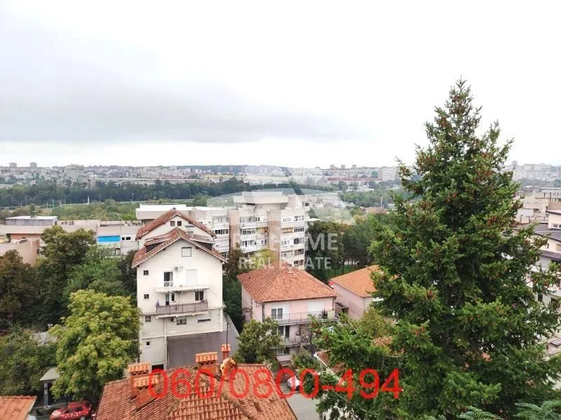 Pogled sa prozora na okolne zgrade i naselje.