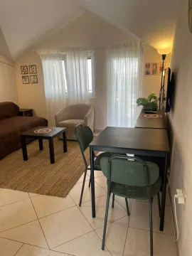 Living room with seating furniture, dining table, and windows. - image 2