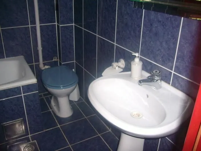 Kupatilo sa plavim pločicama i lavaboom.