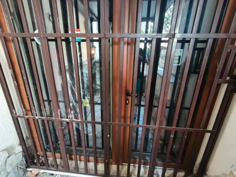 Entrance door with protective metal grilles. - image 3