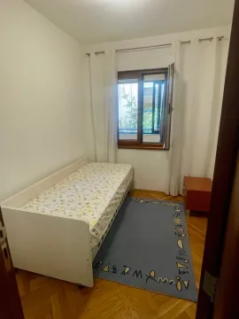 Smaller bedroom with a bed, window, and parquet flooring. - image 8
