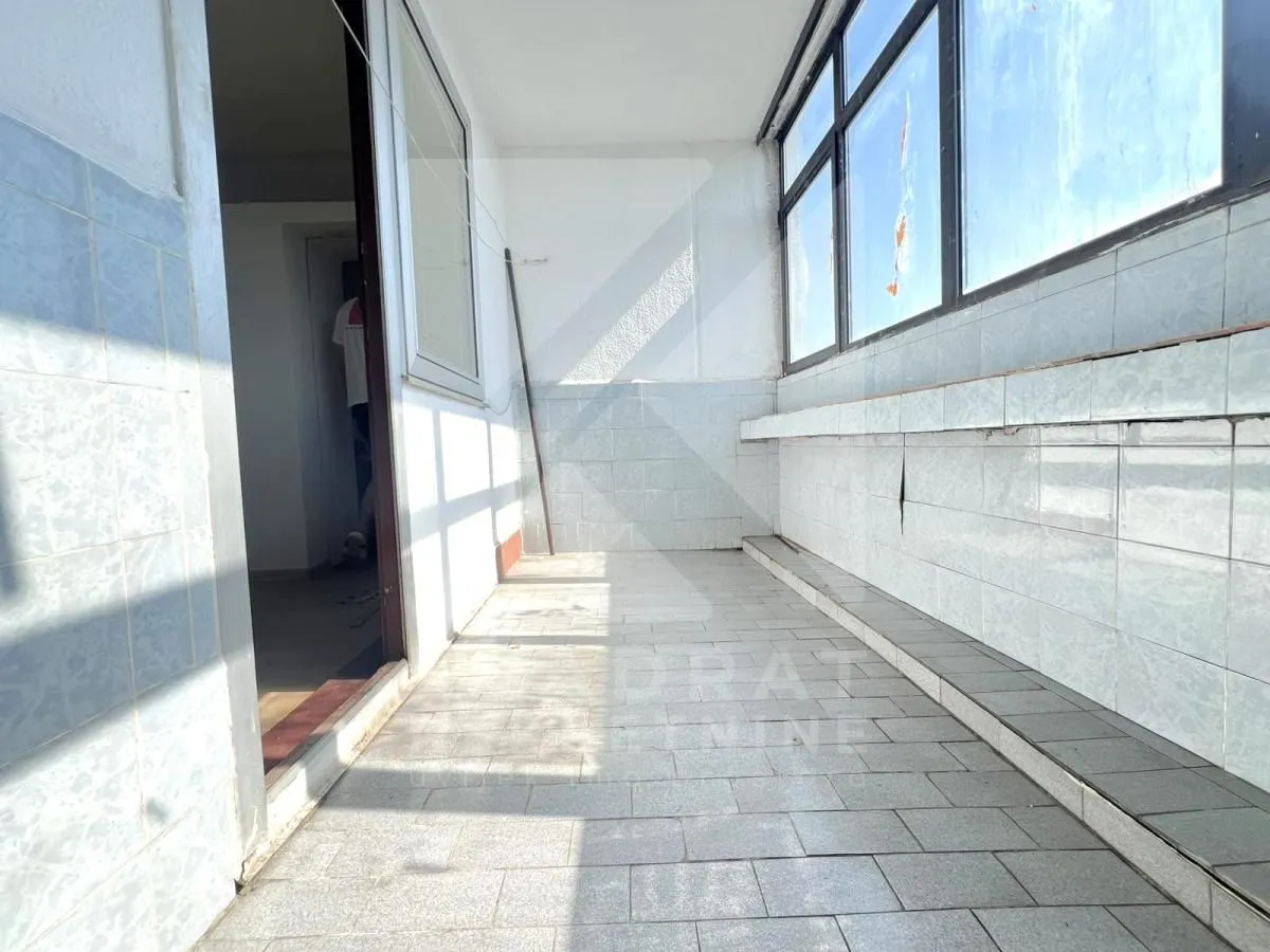 Zastakljeni balkon sa keramičkim pločicama na podu i zidovima.
