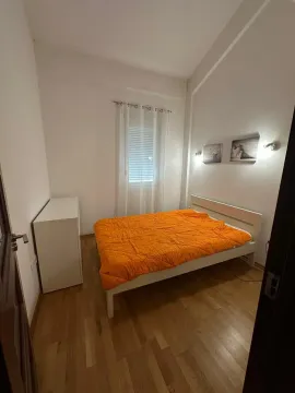 Svijetla spavaća soba sa bijelim krevetom i narandžastom posteljinom. - image 5