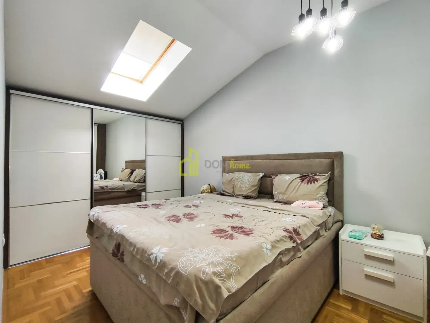 Bedroom with a double bed, large wardrobe, and a skylight.