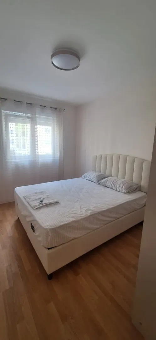 Bright bedroom with a double bed and a window.