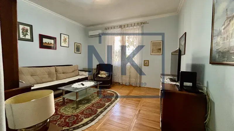Living room with sofa, coffee table, and television.