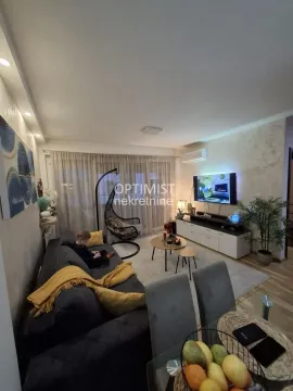 Nameštena dnevna soba sa garniturom, televizorom i trpezarijskim stolom u prvom planu. - image 8