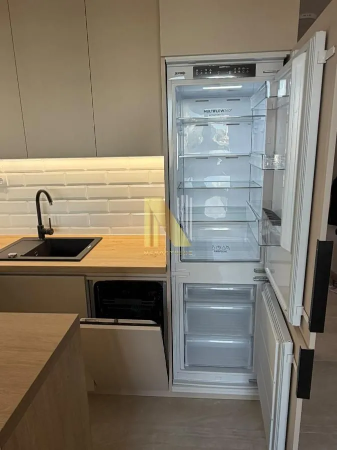 View of a modern equipped kitchen with an integrated refrigerator and sink.