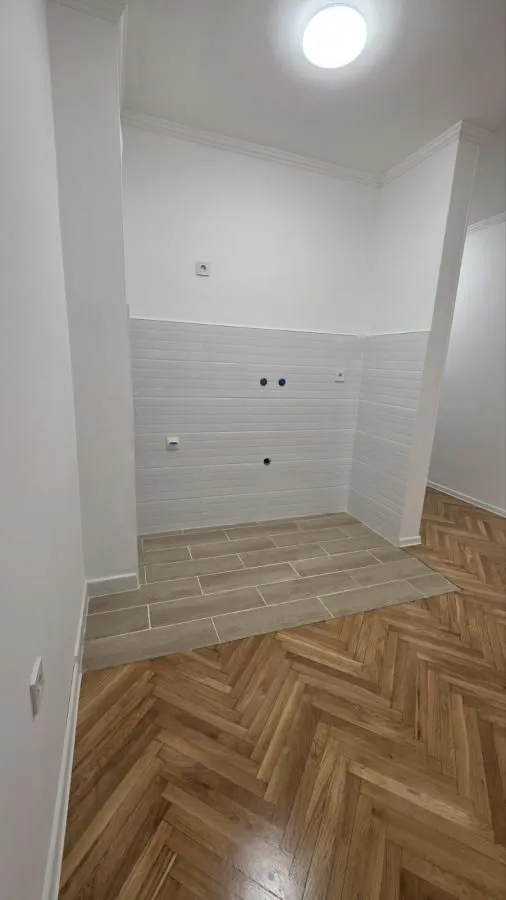 Deo kuhinje sa keramičkim pločicama na podu i zidovima.