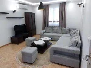 Living room with sofa set, coffee table, and television.