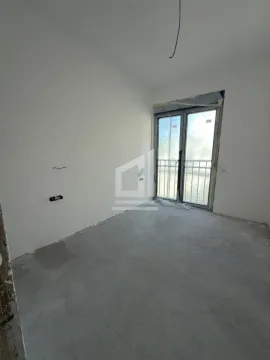 Neopremljena prostorija u izgradnji sa balkonskim vratima i bijelim zidovima. - image 3