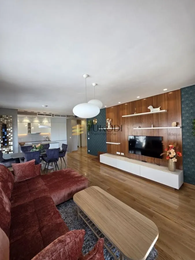 Living room connected to the dining area and kitchen in a modern apartment.