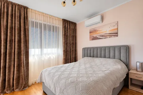 Namještena spavaća soba sa bračnim krevetom, klima uređajem i prozorom sa zavjesama. - image 5