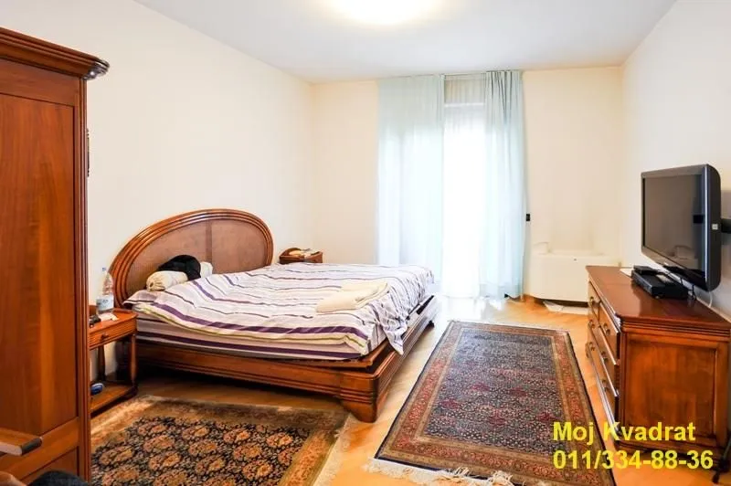 Bedroom with a double bed, wooden furniture, and a television.
