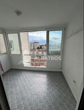 Enclosed balcony with tiled flooring and city views. - image 7