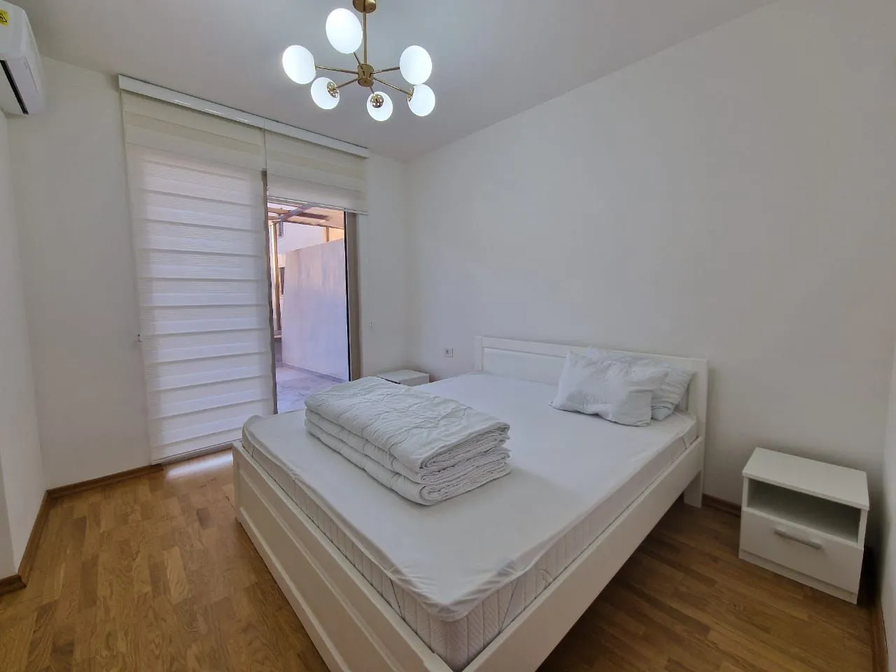 Bedroom with a double bed, bedside table, and access to the terrace.
