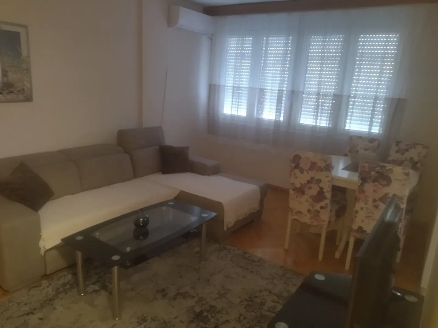 Dnevna soba sa garniturom, stočićem i trpezarijskim stolom.