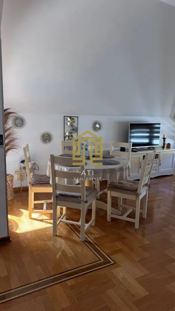 Dnevni boravak sa trpezarijskim stolom i stolicama.