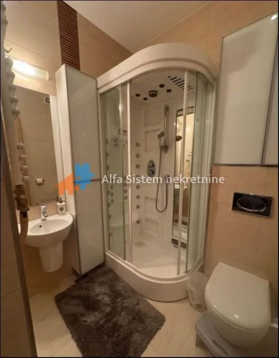 Kupatilo opremljeno tuš kabinom, umivaonikom i wc šoljom.