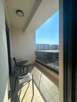 Covered balcony with patio furniture and a city view. - image 6