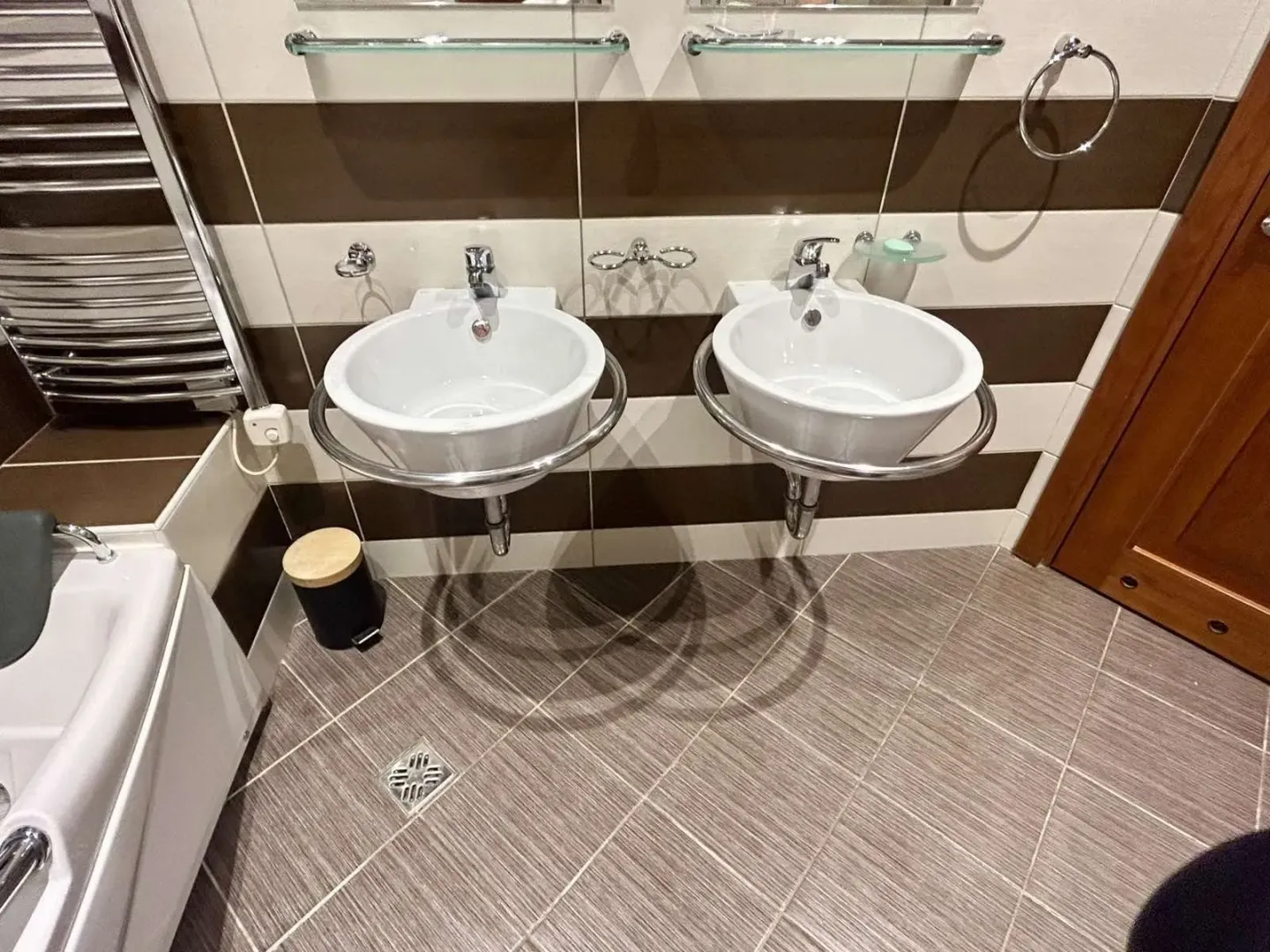 A bathroom with double sinks and modern tiling.