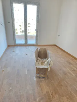 Prazna soba u izgradnji sa parketom i kartonskom kutijom na sredini. - image 7