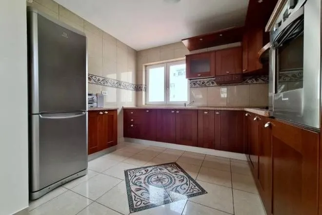 Kuhinja sa drvenim elementima i ugrađenim uređajima.