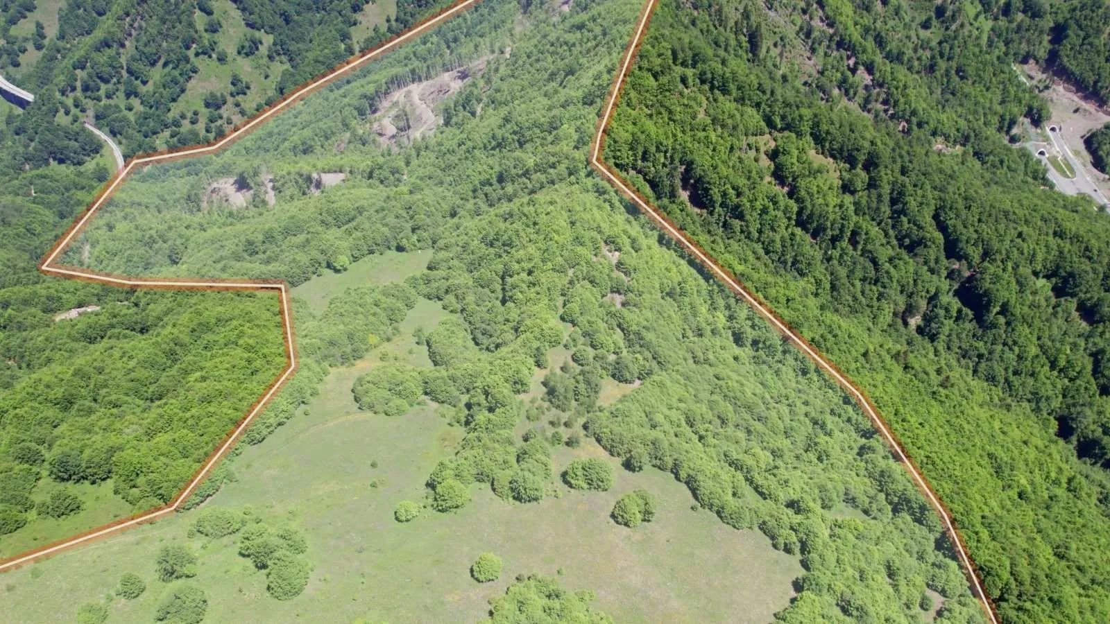 Vazdušni snimak velikog zemljišta sa označenim granicama parcele.