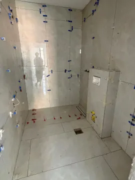 Bathroom undergoing tiling work with installed tiles and leveling spacers. - image 2