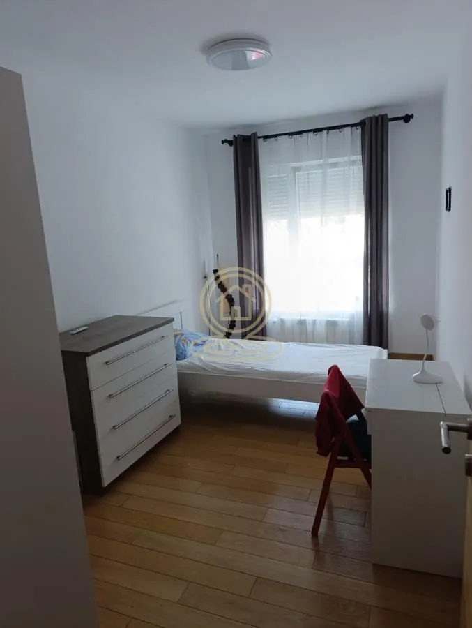 Small bedroom with a bed, dresser, and a desk.