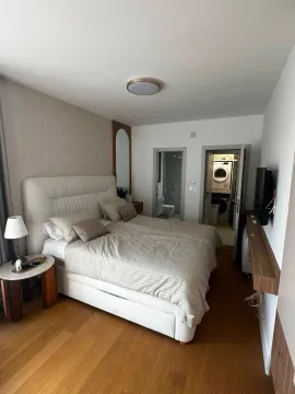 Modern bedroom with a double bed and a bathroom in the background. - image 8