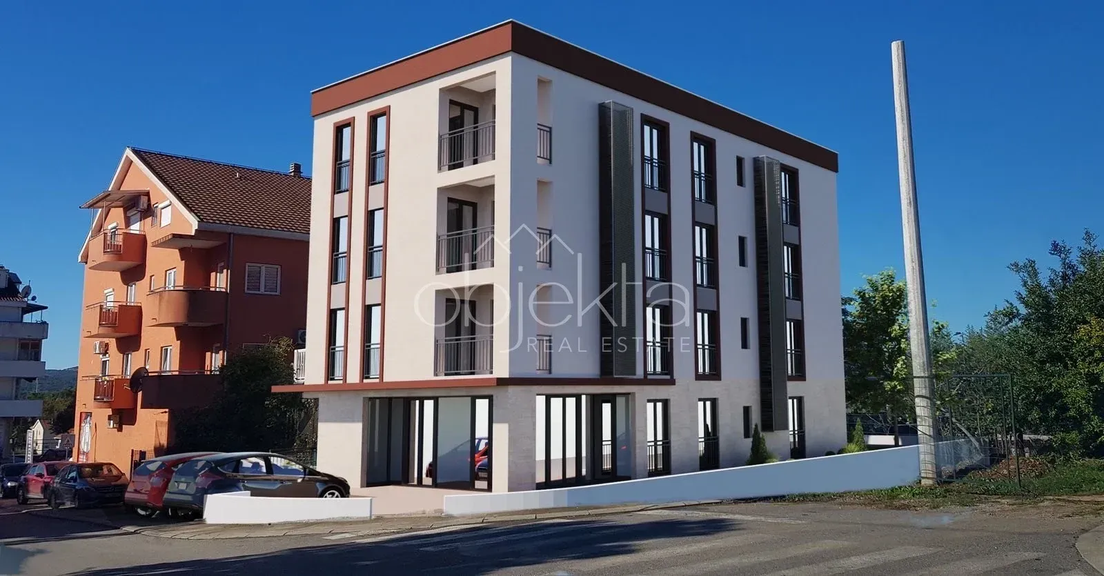 Exterior view of a modern residential building with balconies and parking.