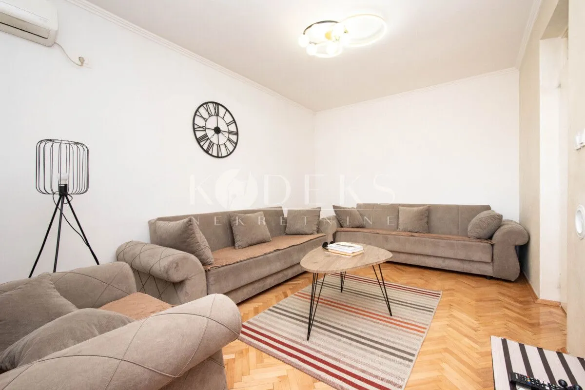 Living room furnished with a sofa set, coffee table, and decorative elements.
