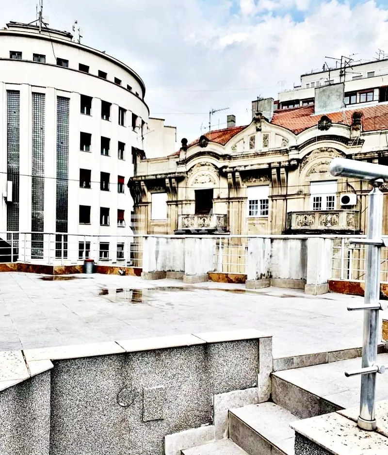 Spacious rooftop terrace overlooking surrounding buildings.