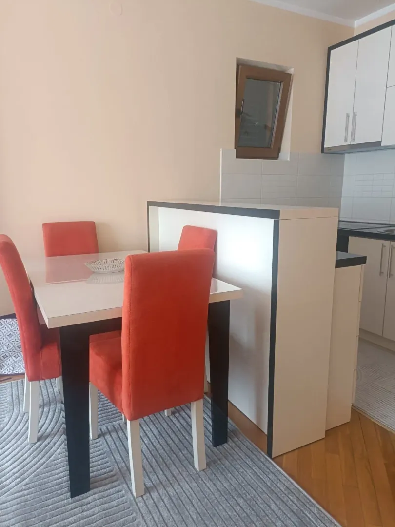 Trpezarija sa crvenim stolicama i pogledom na kuhinjski dio.