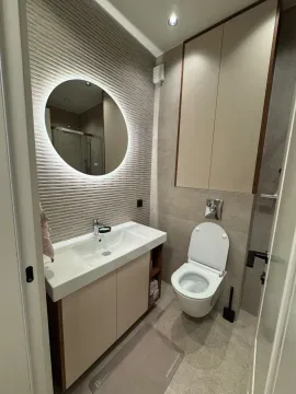 Moderno opremljeno kupatilo sa umivaonikom, ogledalom i WC šoljom. - image 5