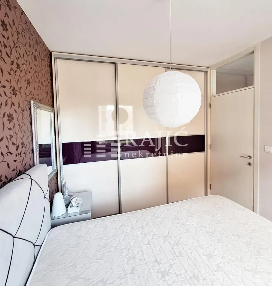 Furnished bedroom with a large wardrobe and a double bed.