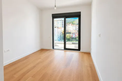 Prazna svijetla soba sa drvenim podom i balkonskim vratima. - image 6