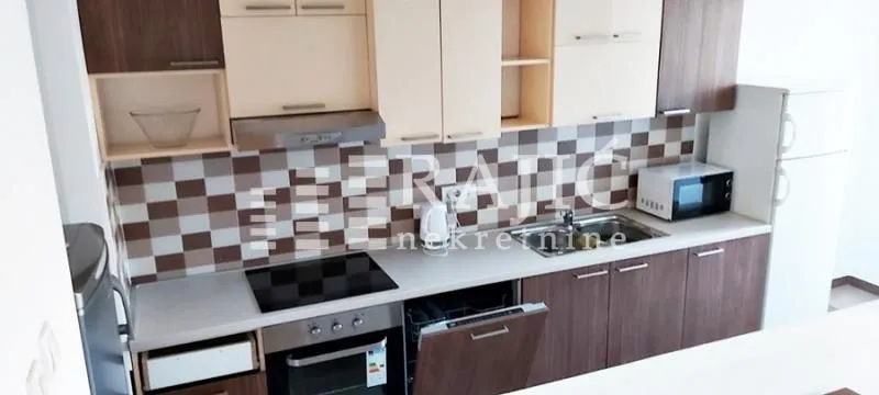 Modern kitchen with brown and white cabinets and built-in appliances.