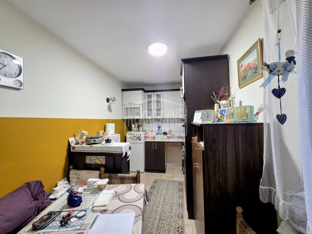 Manja kuhinja sa trpezarijskim stolom u prvom planu.