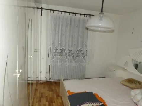Furnished bedroom with a double bed, large wardrobe, and a window with curtains. - image 22