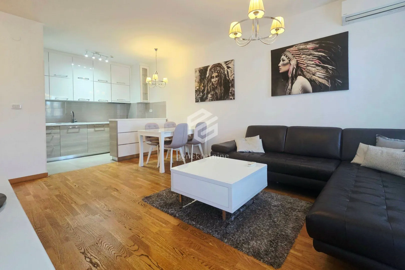 Living room with a sofa set and dining area within an open-plan space with the kitchen.