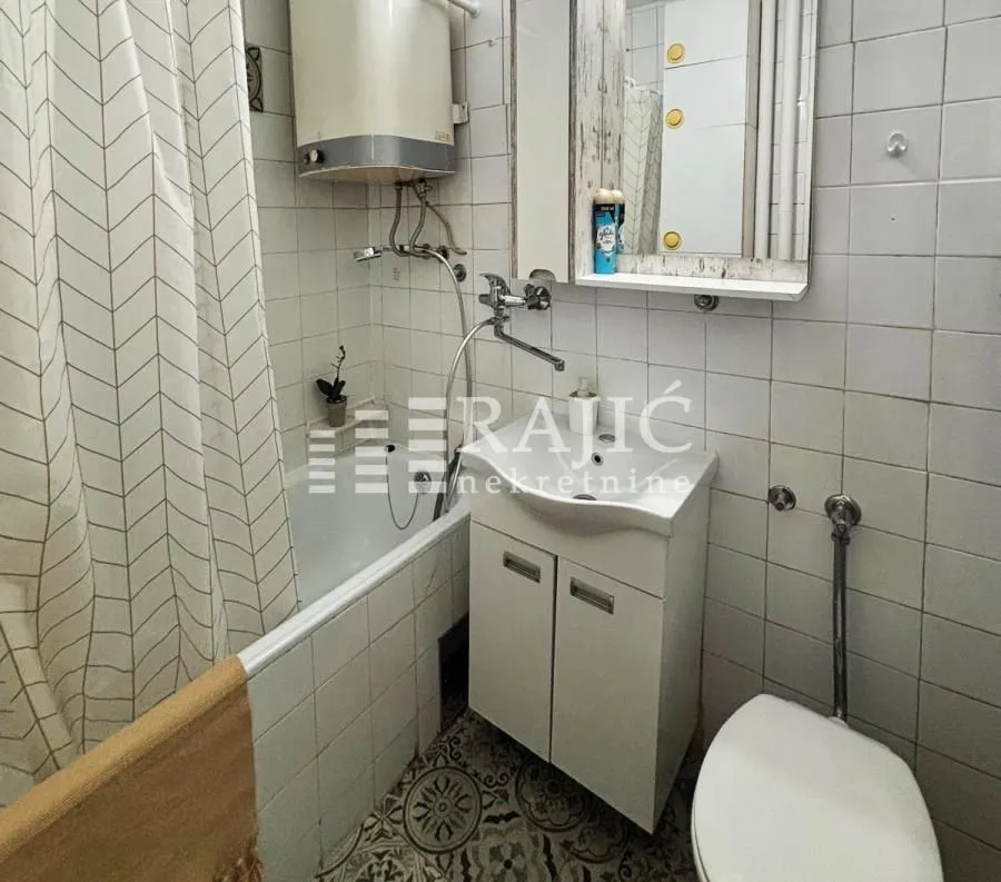 Smaller bathroom with a bathtub, washbasin, and toilet.