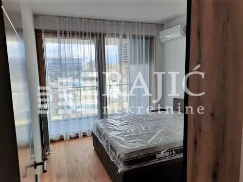 Bedroom with a double bed and large balcony doors.